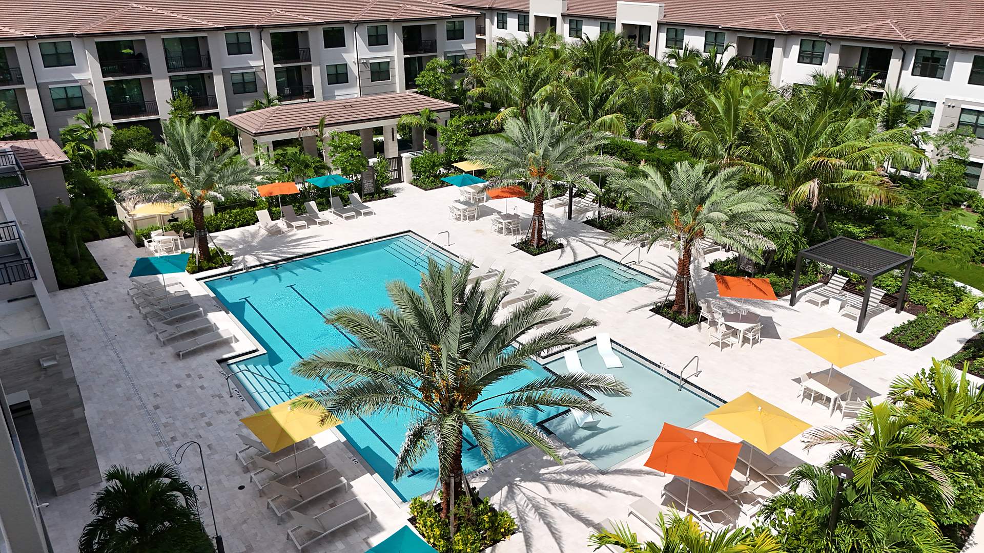 Aerial of the amenity courtyard and pool at Mosaic Palms with palms planted throughout